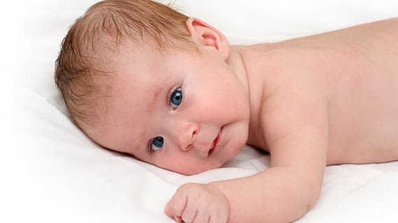 Baby crawling on white sheet
